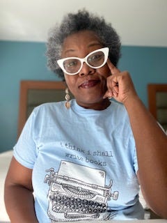 Photo of Nana Ama Danquah in white glasses and a blue t-shirt